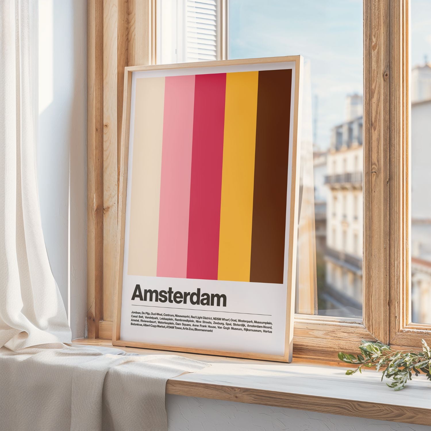Framed poster with vertical stripes and 'Amsterdam' text on a windowsill.
